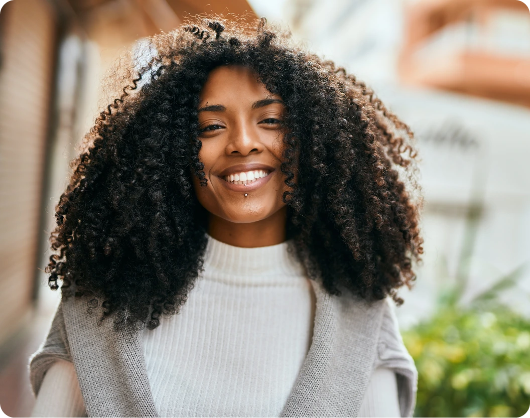 Woman with curly hair smiling brightly