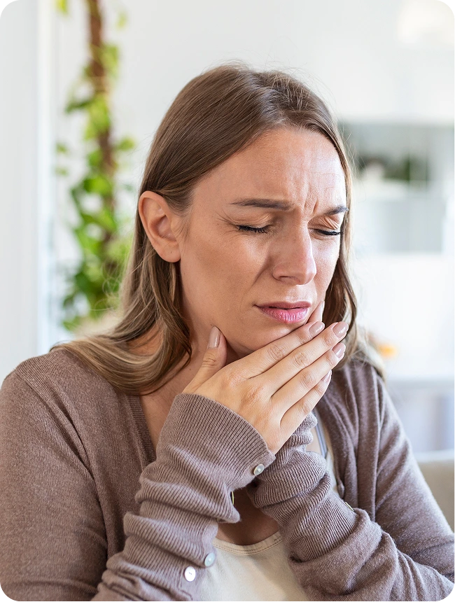 Woman with hand on jaw, eyes closed, showing TMJ discomfort