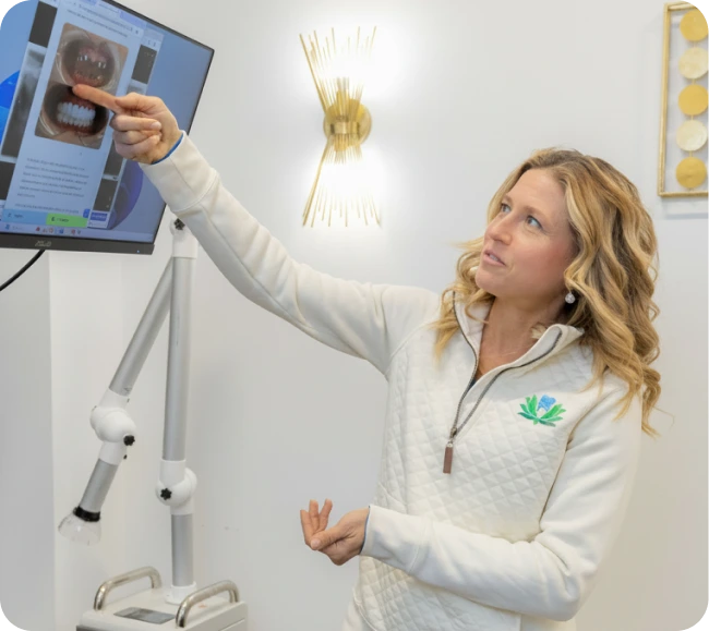 Dentist pointing to gum disease x-ray on monitor during patient consultation